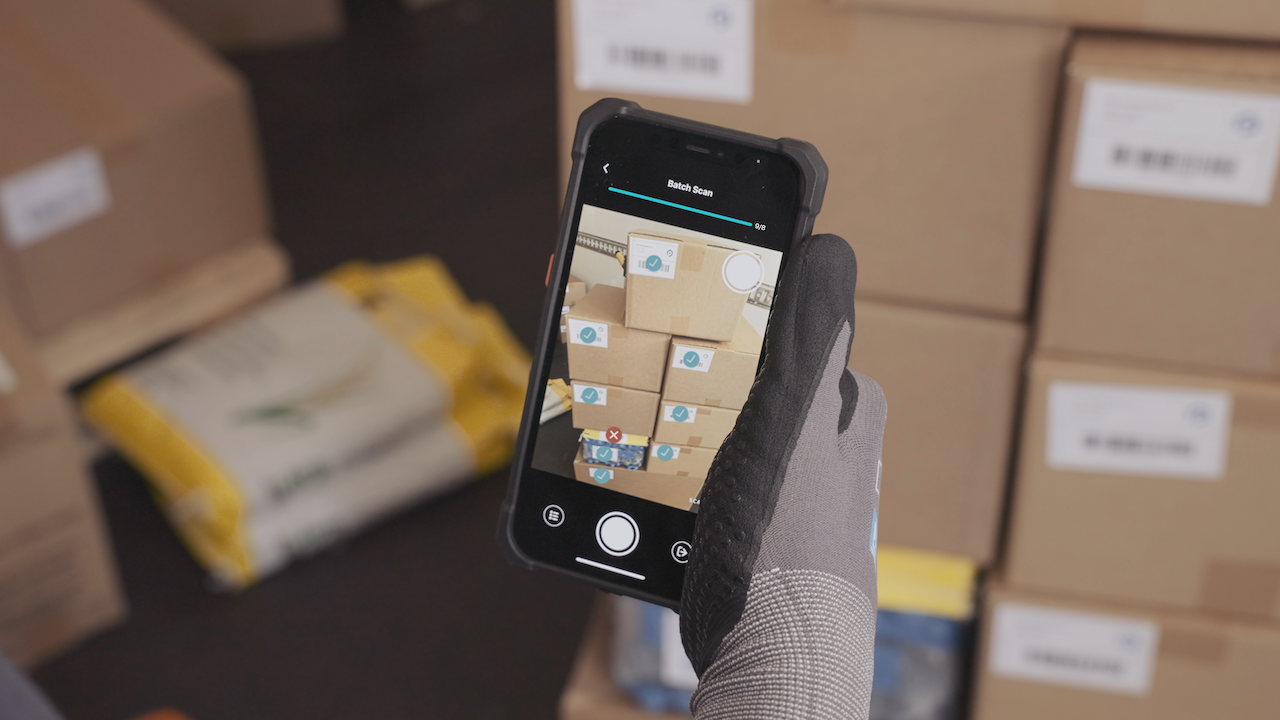 Data democratization tool being used on a smartphone to identify incorrect packages in a delivery