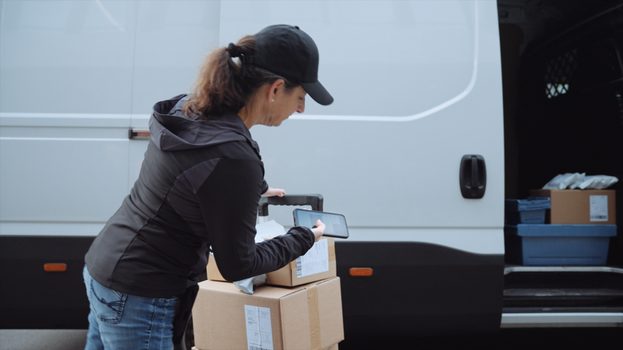 Last-mile delivery worker using camera-based scanning and Scandit SparkScan to scan a barcode.