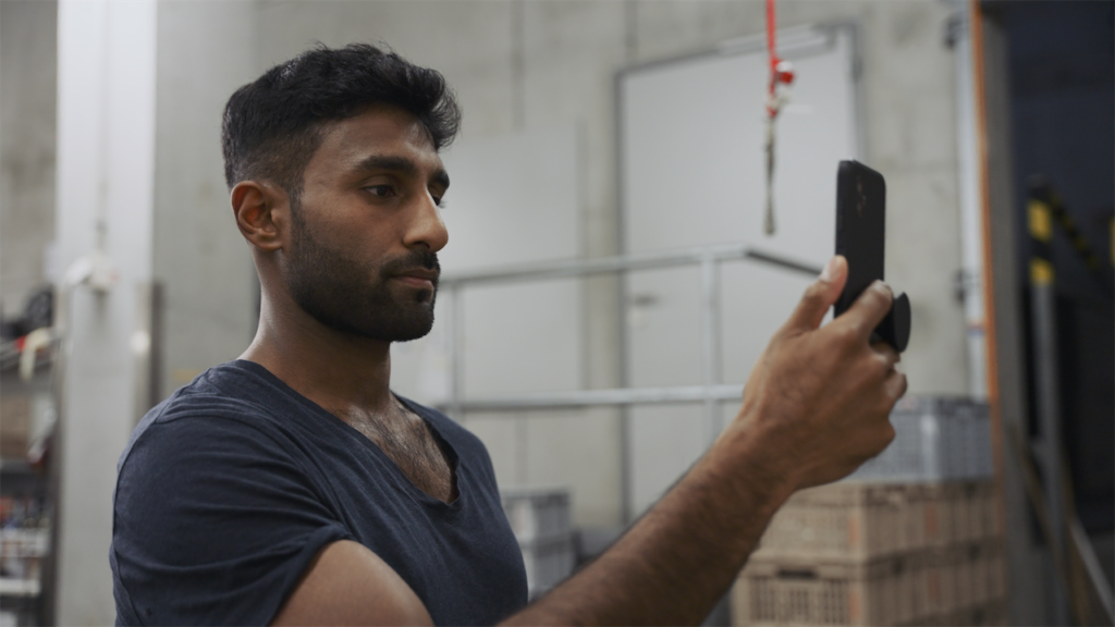 Warehouse worker using intelligent data capture on a rugged smartphone.